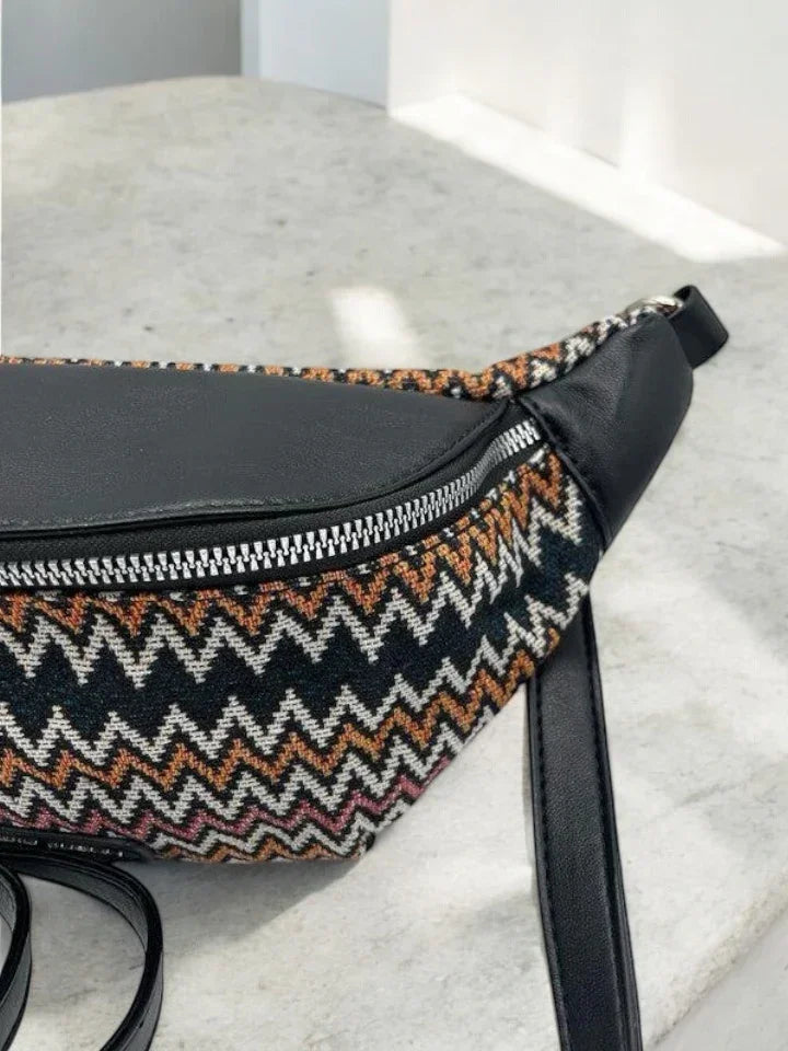 Chevron patterned fabric and black leather belt bag on a light stone surface, Le Petit Placard