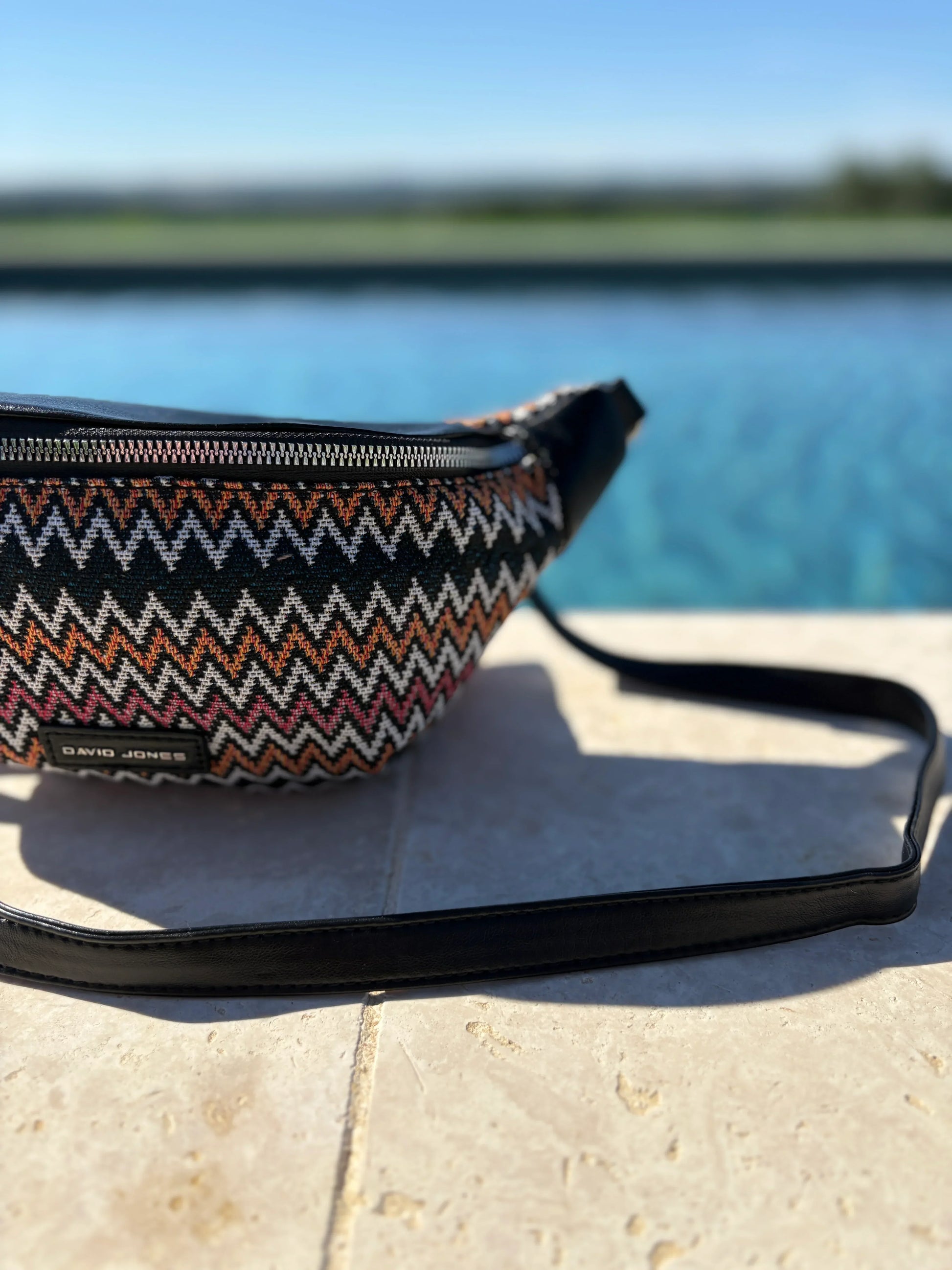 Zigzag patterned David Jones bum bag by a pool, trendy accessory at Le Petit Placard