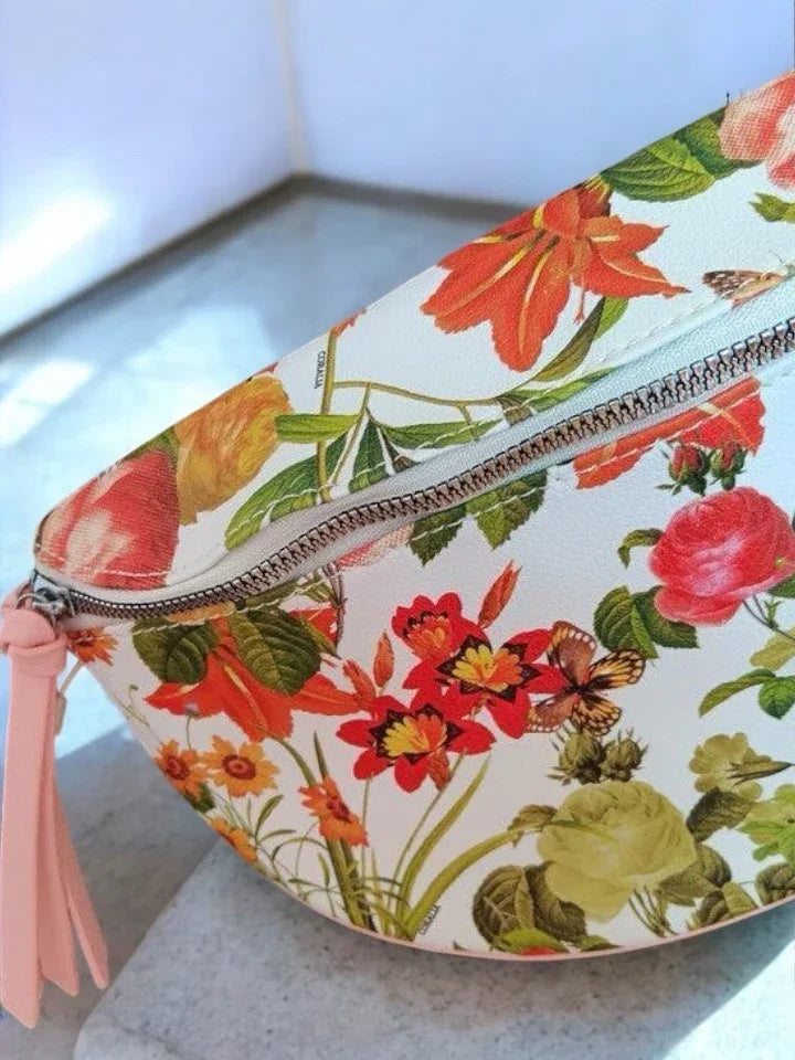 Floral print sac banane with zipper, trendy accessory from Le Petit Placard on marble surface.