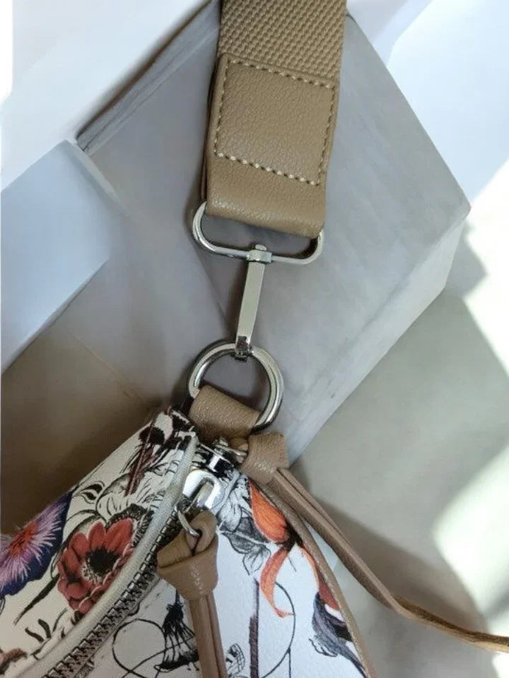 Close-up of beige and floral Le Petit Placard crossbody bag strap and zipper detail