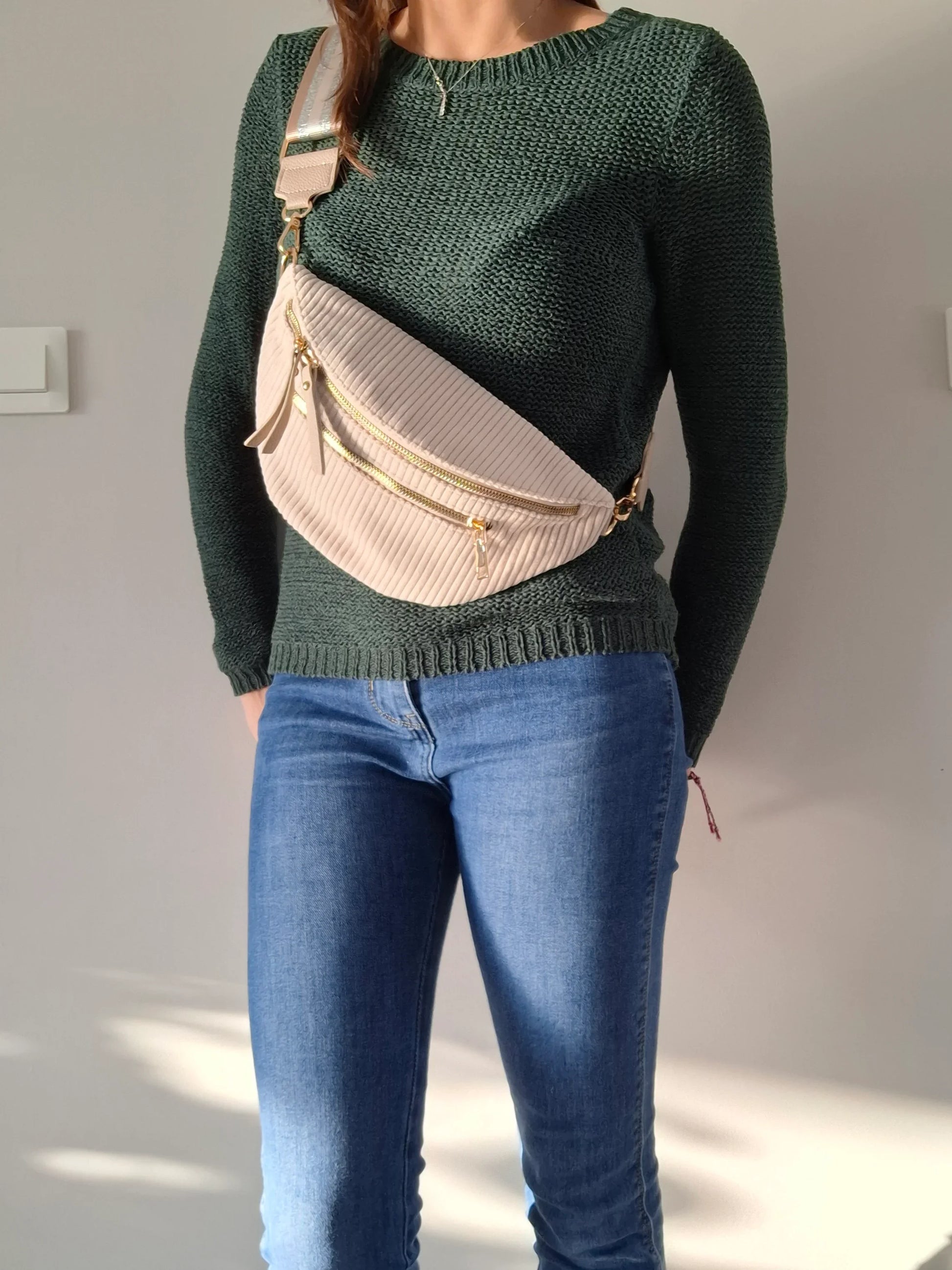 Sac banane velours côtelé beige porté en bandoulière, zips dorés et sangle géométrique, look casual chic