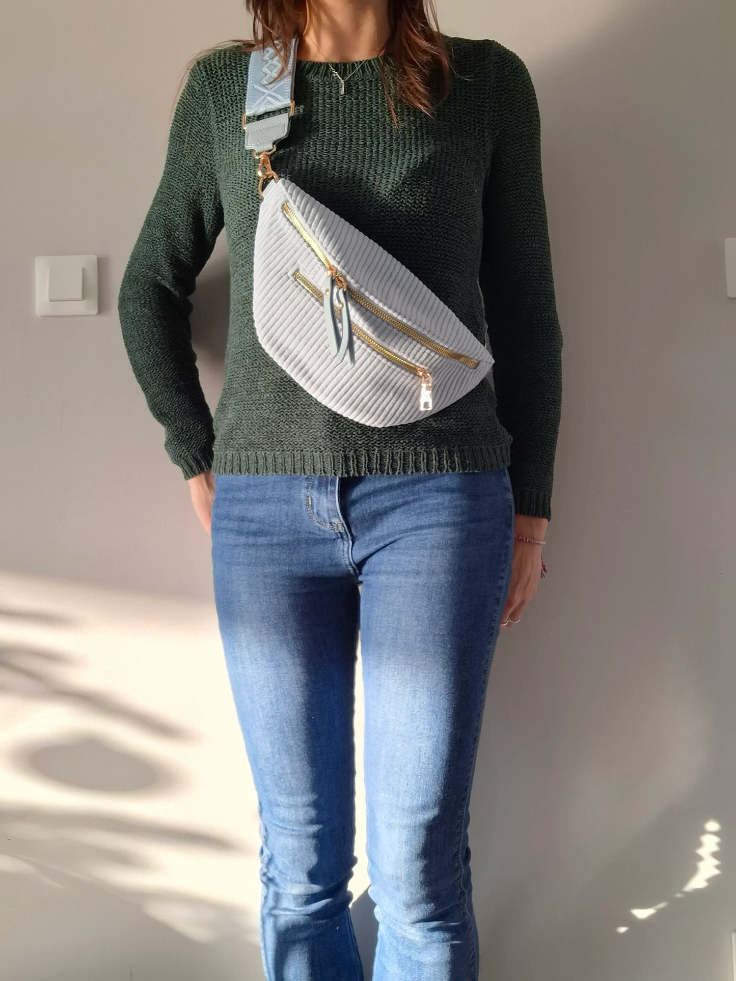 Sac banane velours côtelé bleu ciel porté en bandoulière, 2 zips dorés et sangle géométrique, look casual femme