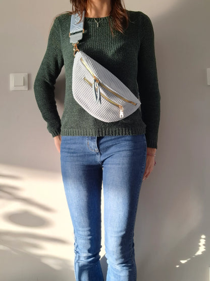Sac banane velours côtelé bleu ciel porté en bandoulière, 2 zips dorés et sangle géométrique, look casual femme
