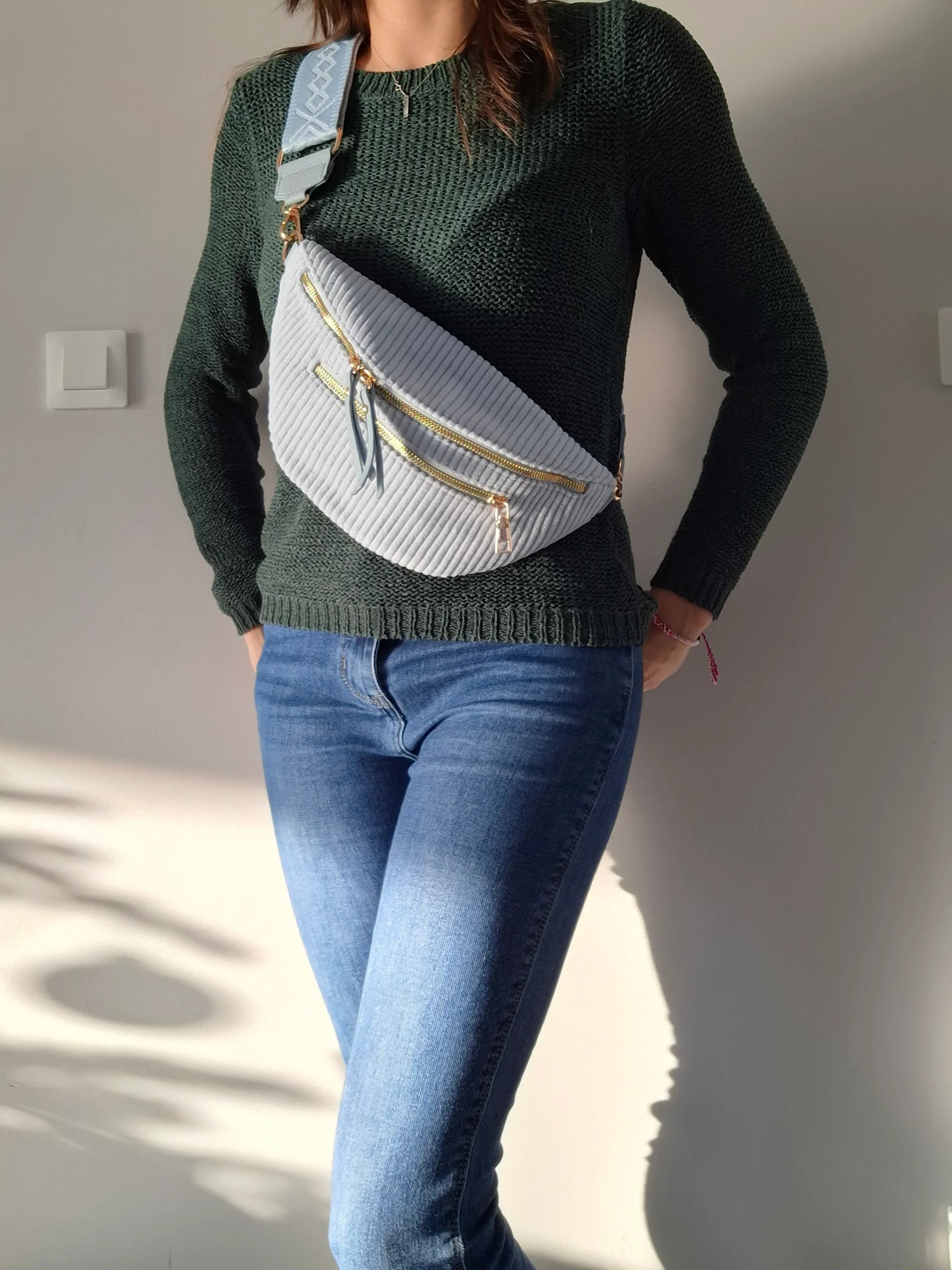 Sac banane velours côtelé bleu ciel porté en bandoulière, 2 zips dorés et sangle géométrique, look casual femme