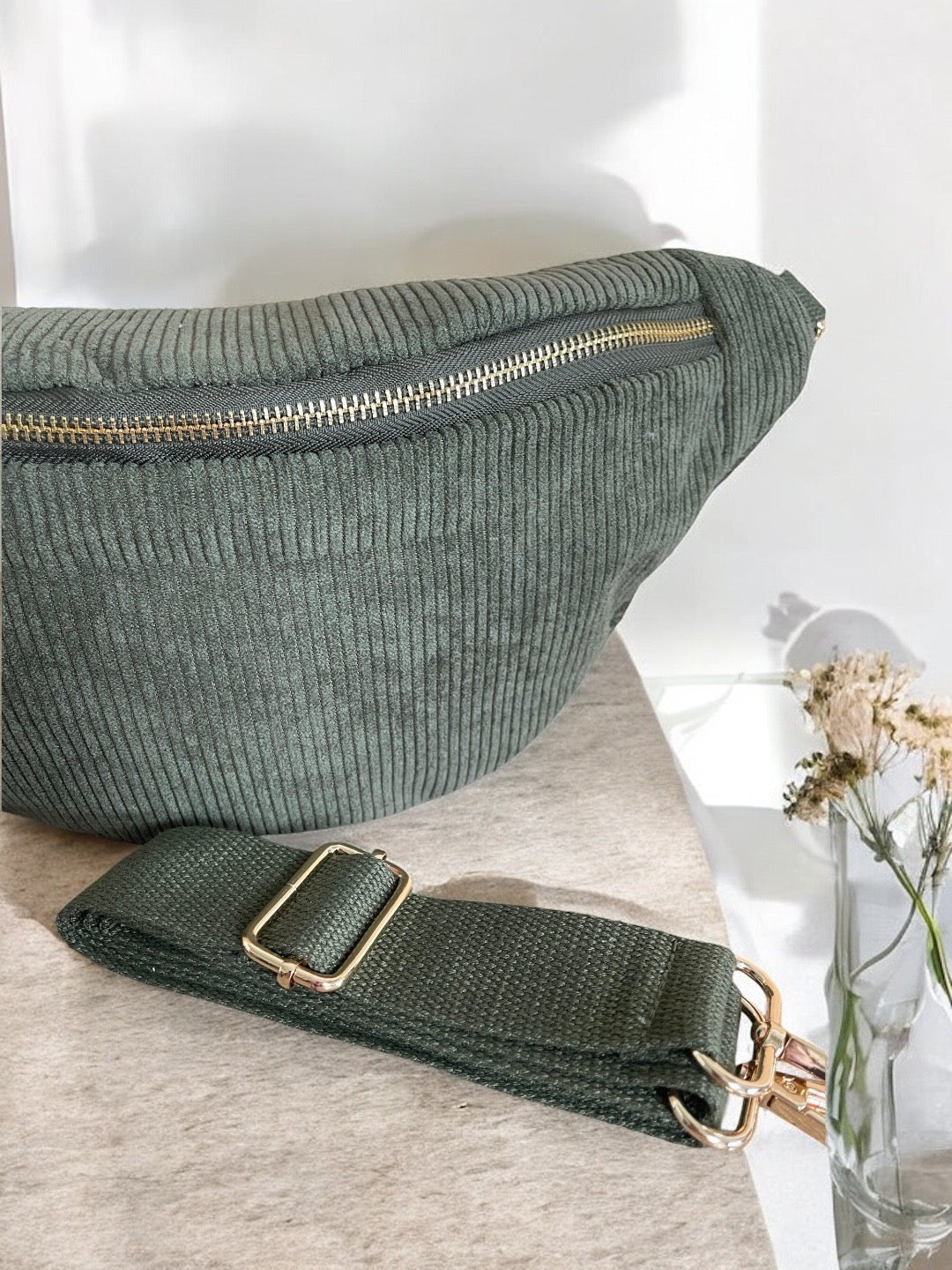 Green corduroy bum bag with gold zipper, detachable strap on table, Le Petit Placard accessory