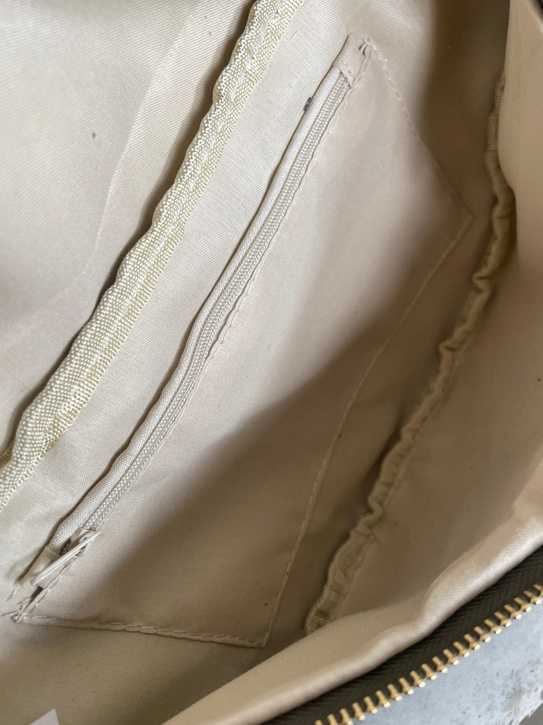 Interior of beige Le Petit Placard bag with zip pocket and fabric lining
