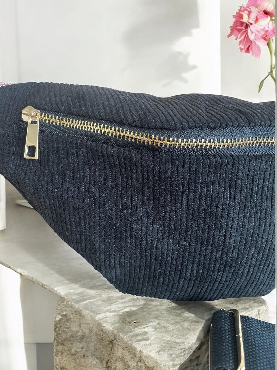 Navy blue corduroy bum bag with gold zipper on marble surface, trendy accessory at Le Petit Placard