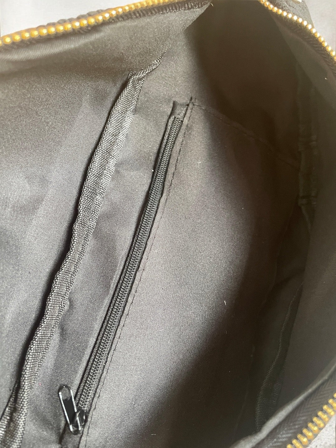 Interior of black zippered bag with fabric lining and inner pocket, Le Petit Placard accessories