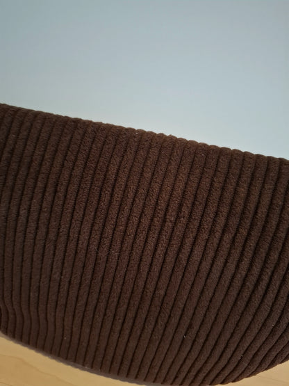 Gros plan sur le tissu velours côtelé marron chocolat foncé du sac banane, texture relief bien visible
