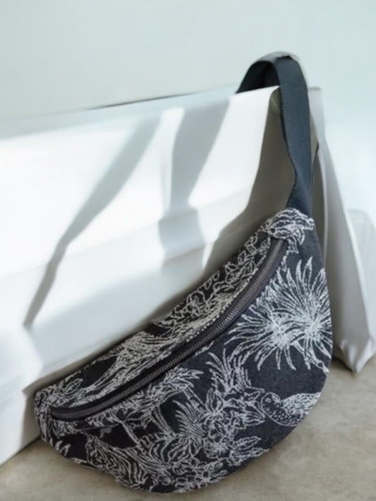 Trendy black and white patterned belt bag from Le Petit Placard resting indoors near sunlight