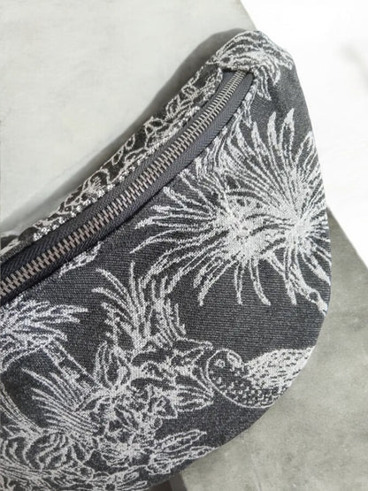 Close-up of a fabric belt bag with white tropical print, trendy accessory at Le Petit Placard