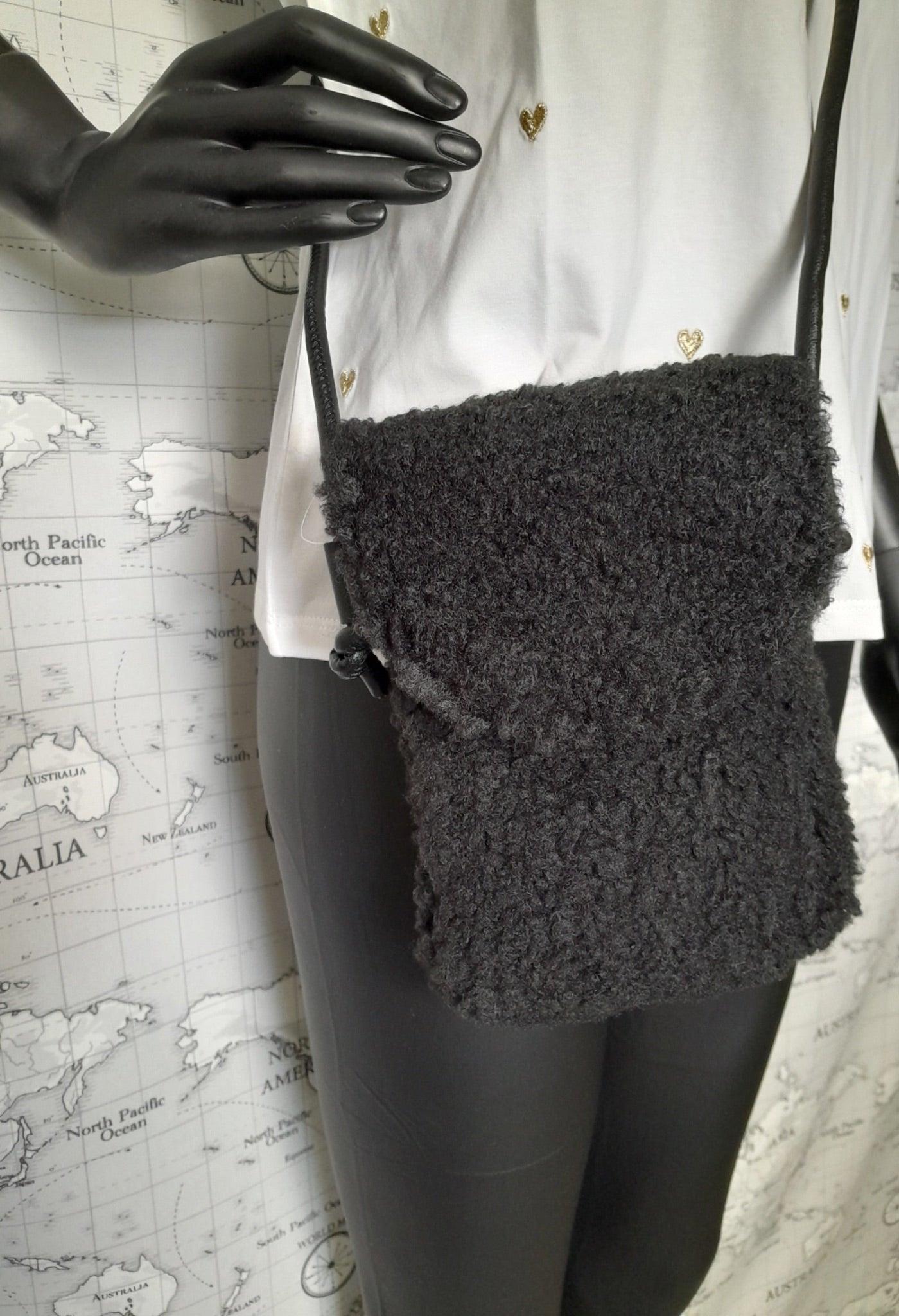 Black faux fur crossbody bag with flap on mannequin, trendy accessory Le Petit Placard