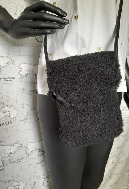 Black faux fur crossbody bag with flap on mannequin, trendy accessory Le Petit Placard