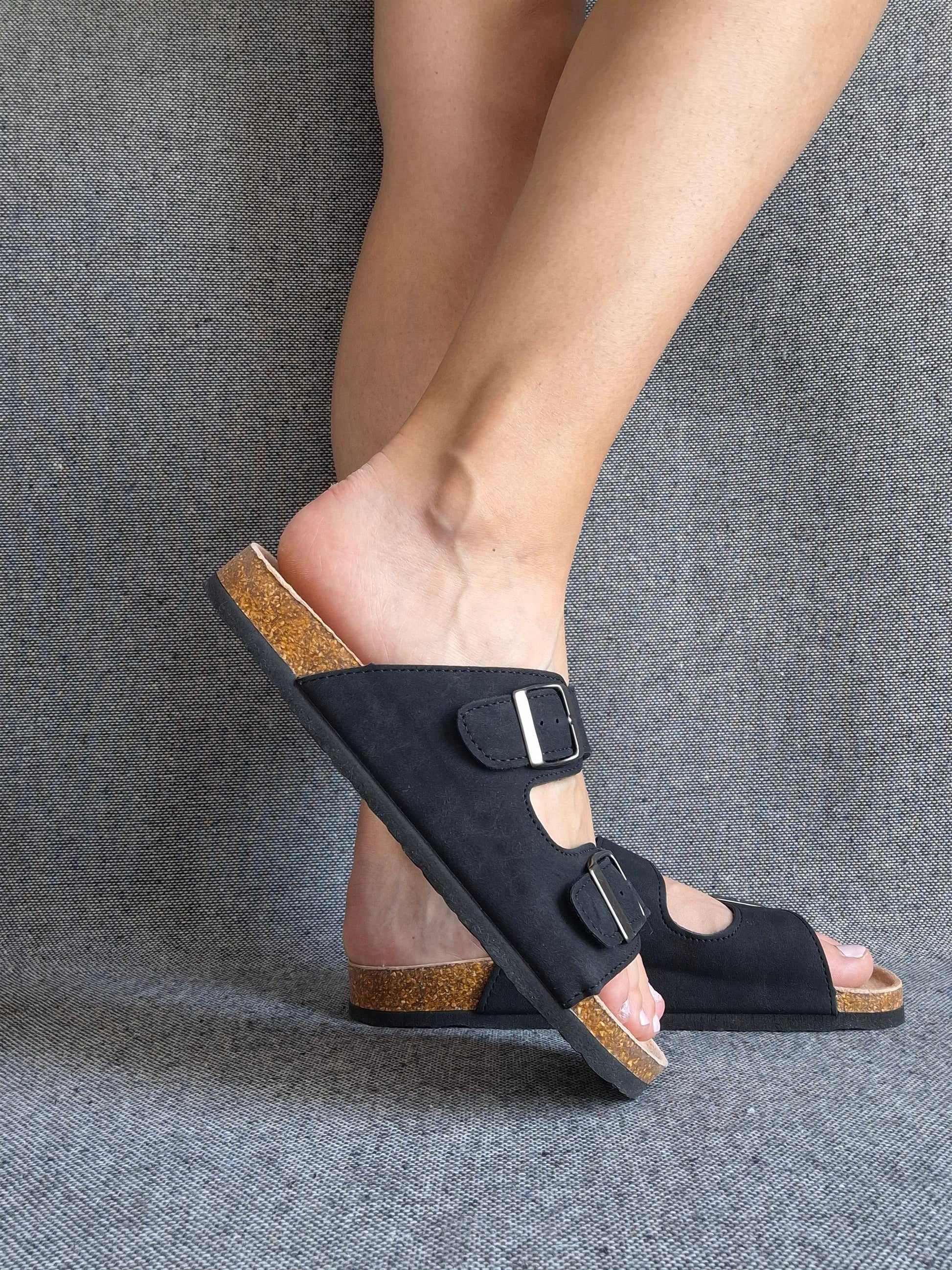 Sandale cuir noir femme style Birkenstock à double boucle et semelle liège, portée de profil