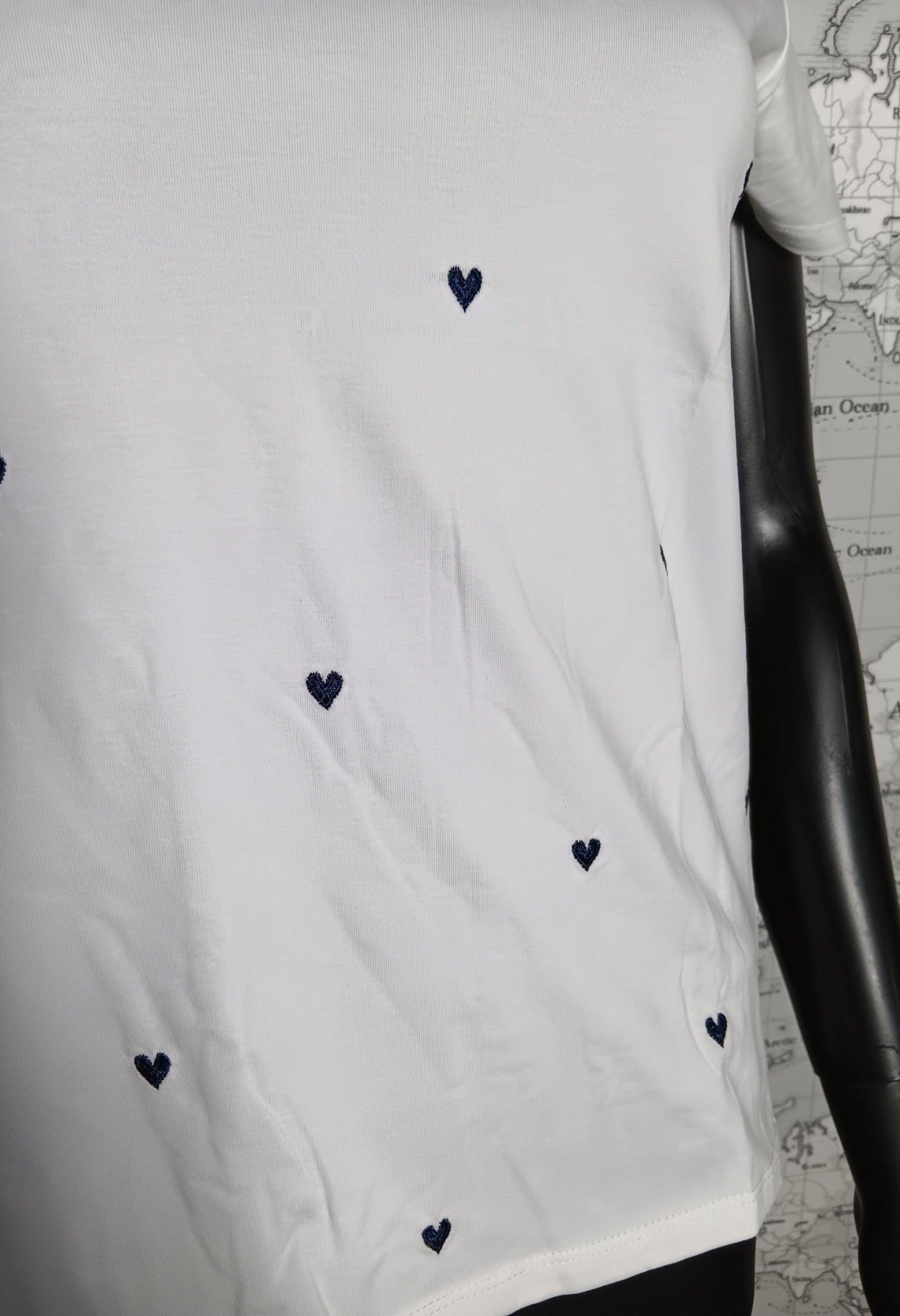 T-shirt blanc avec petits cœurs bleus brodés, visible sur mannequin noir.