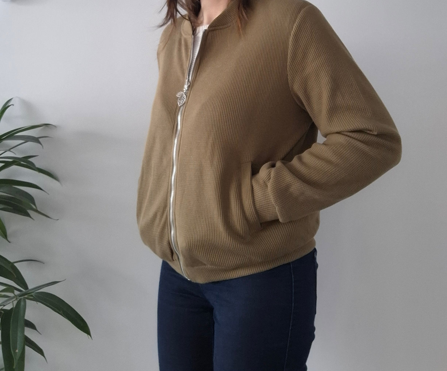 Woman wearing a beige zip-up Laura Jo jacket from Le Petit Placard