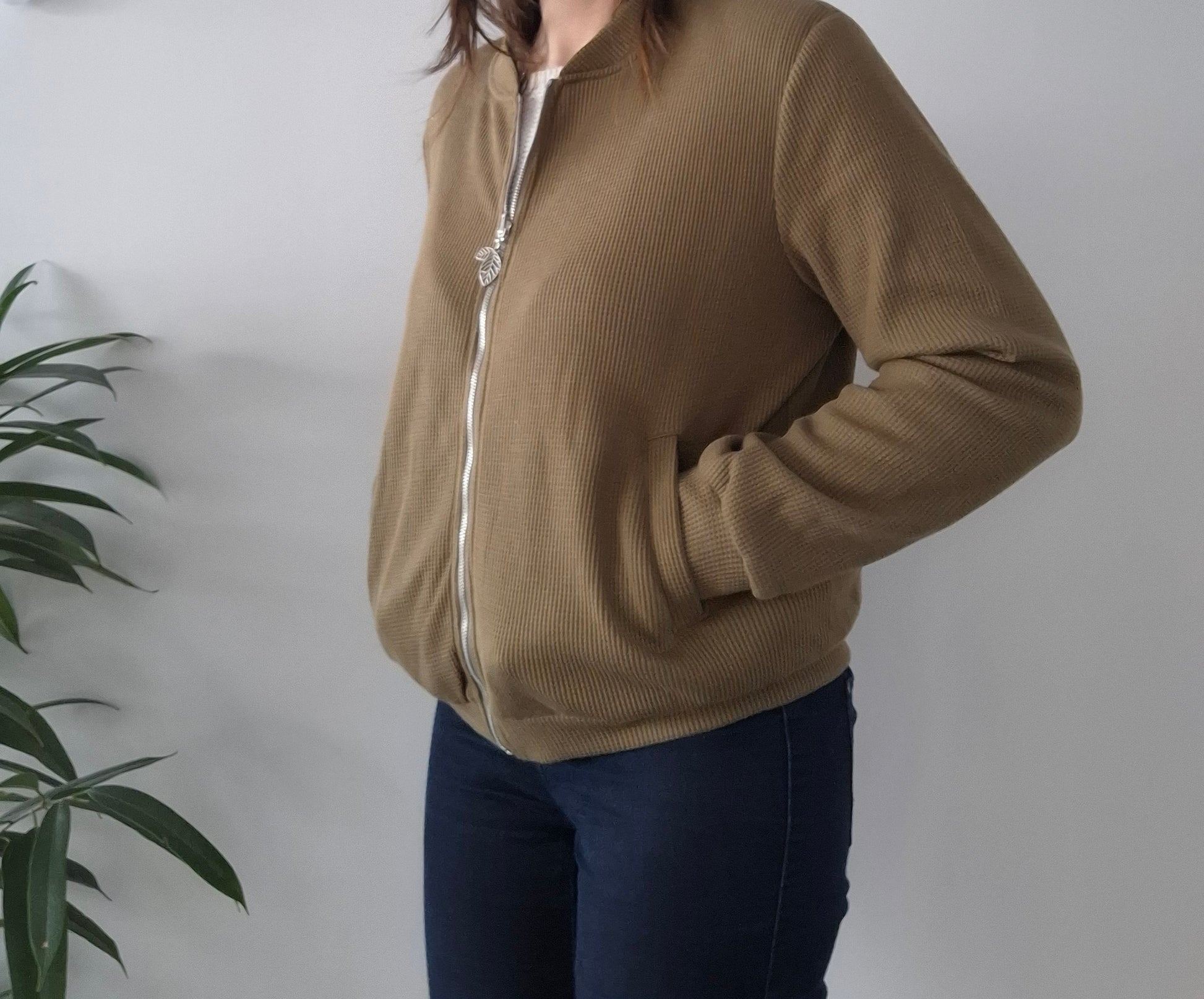 Woman wearing a beige zip-up Laura Jo jacket from Le Petit Placard