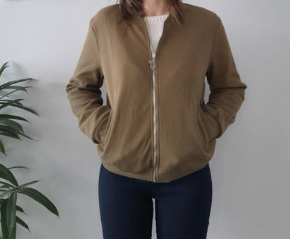 Woman wearing a brown zip-up jacket from Le Petit Placard, casual style, indoor setting