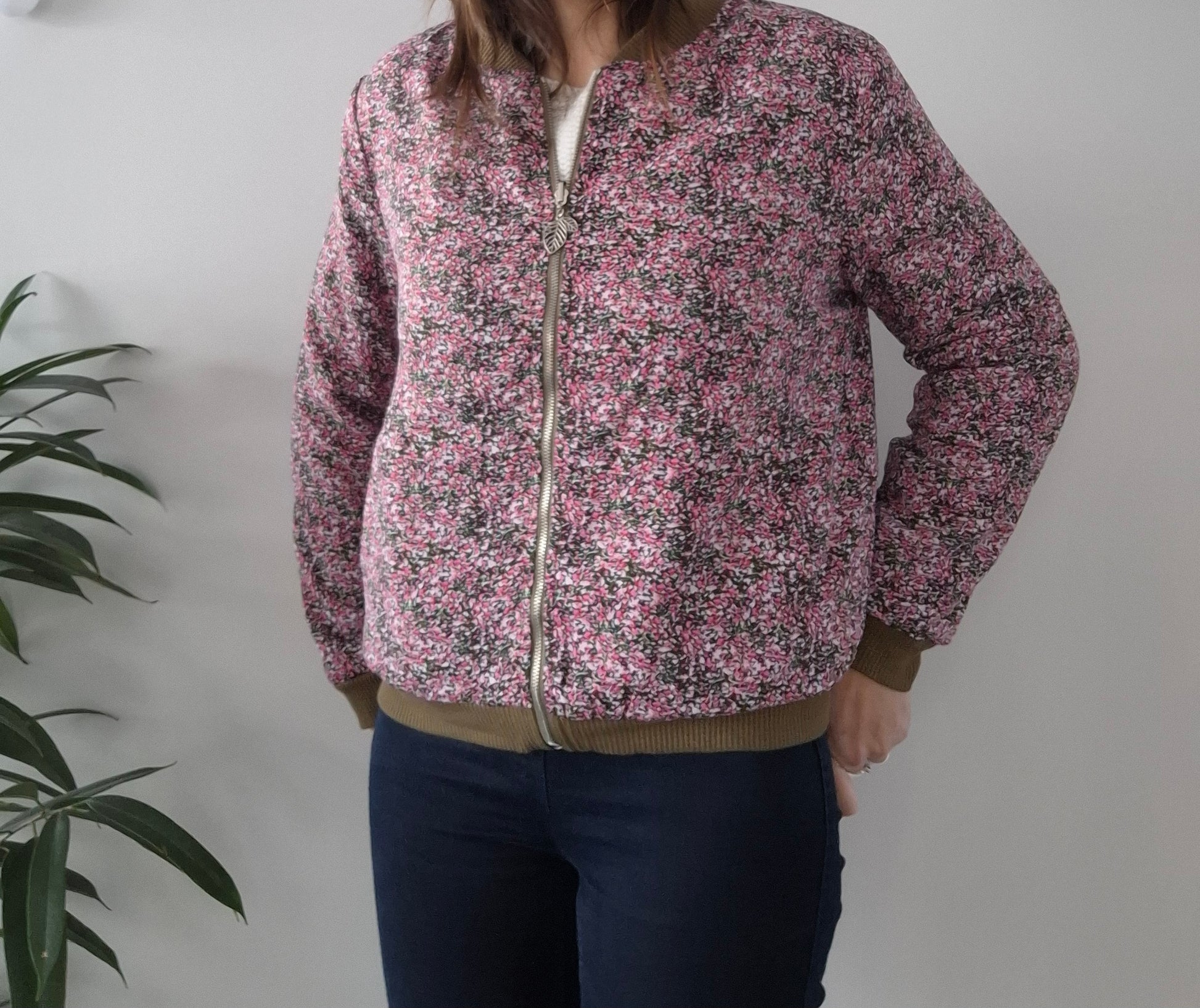 Woman wearing pink floral zip-up bomber jacket from Le Petit Placard, casual outfit style
