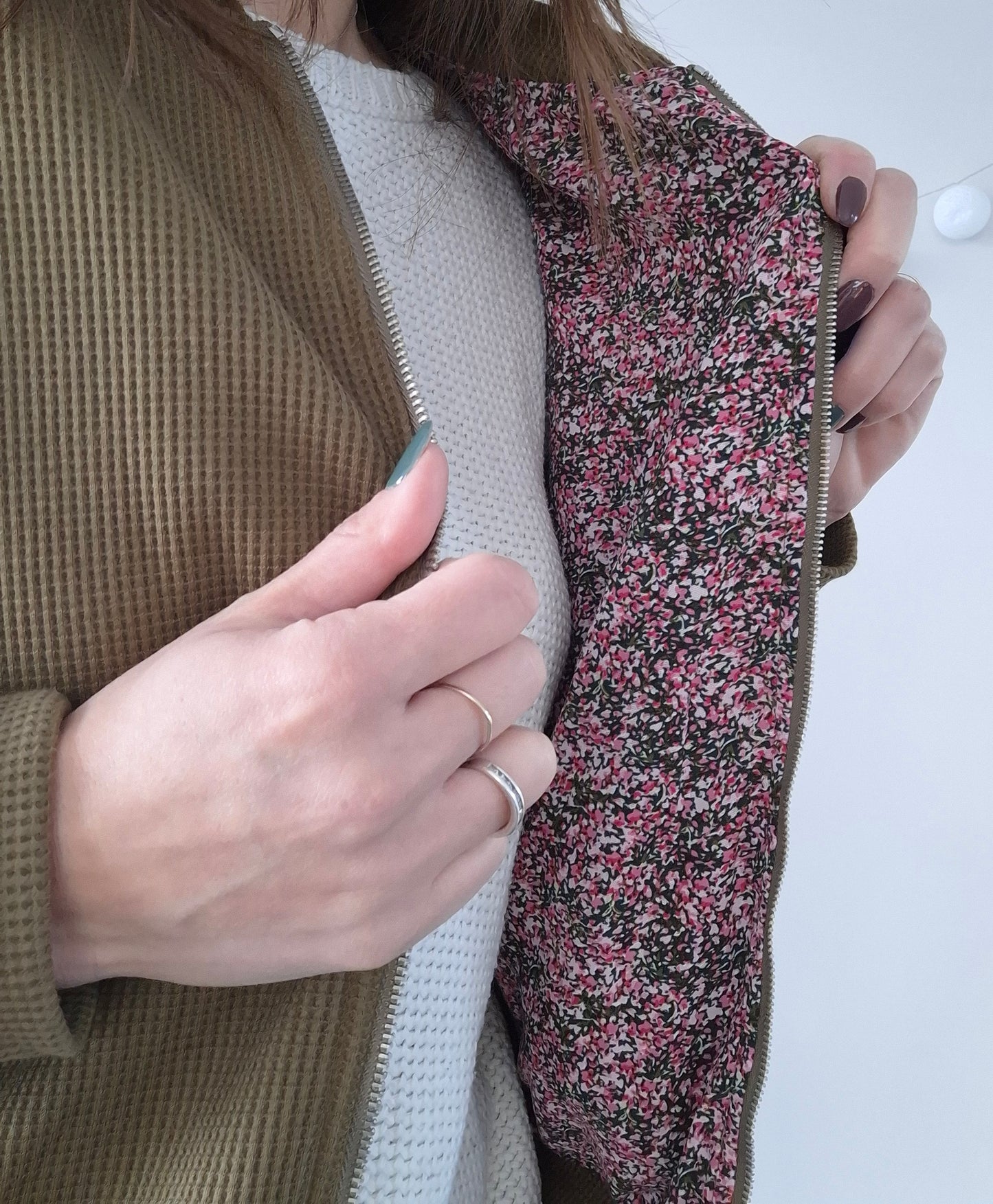 Woman opening khaki Laura Jo raincoat showing floral lining, trendy outerwear Le Petit Placard