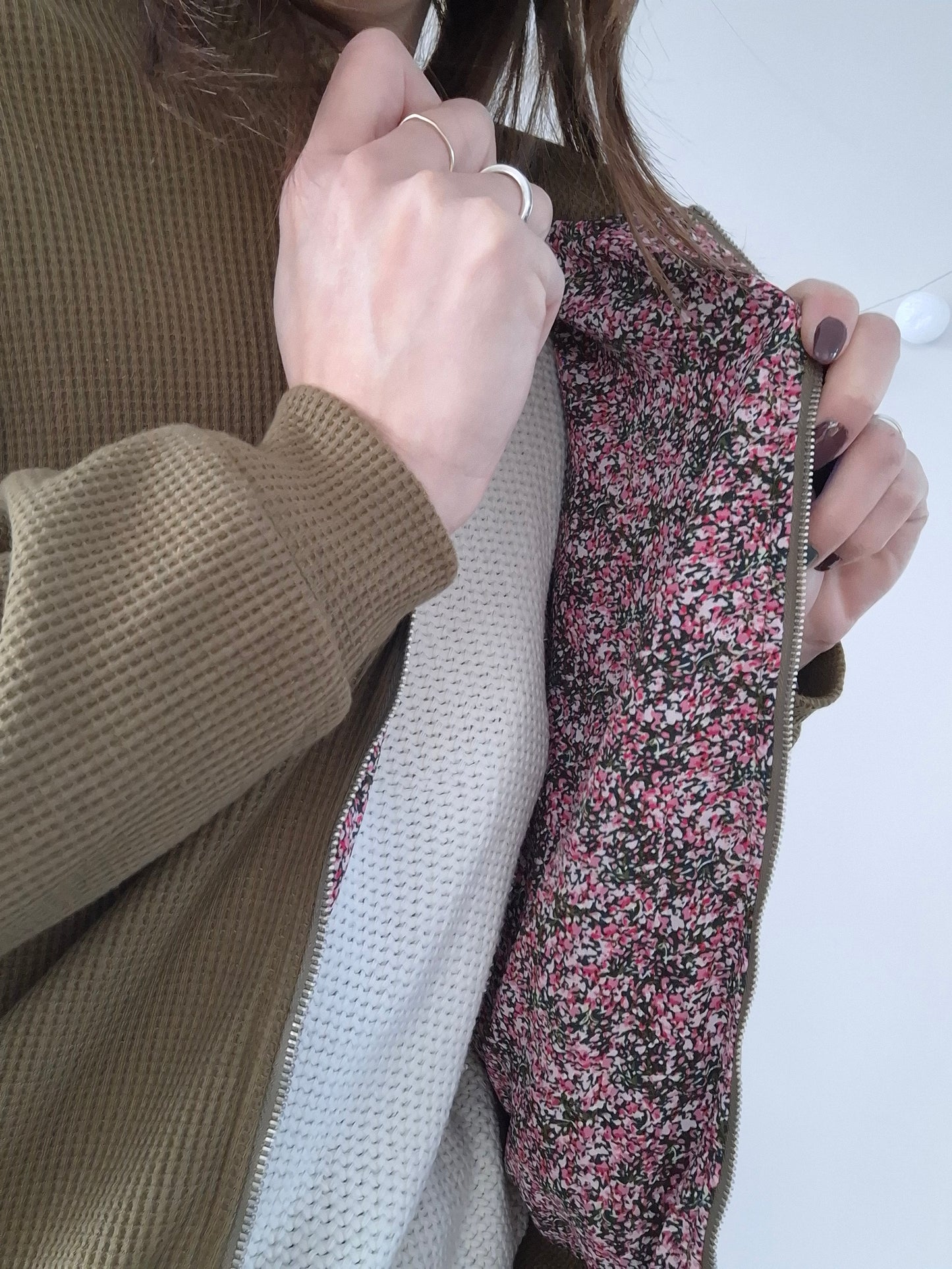 Close-up of a khaki jacket with a floral pink lining from Le Petit Placard