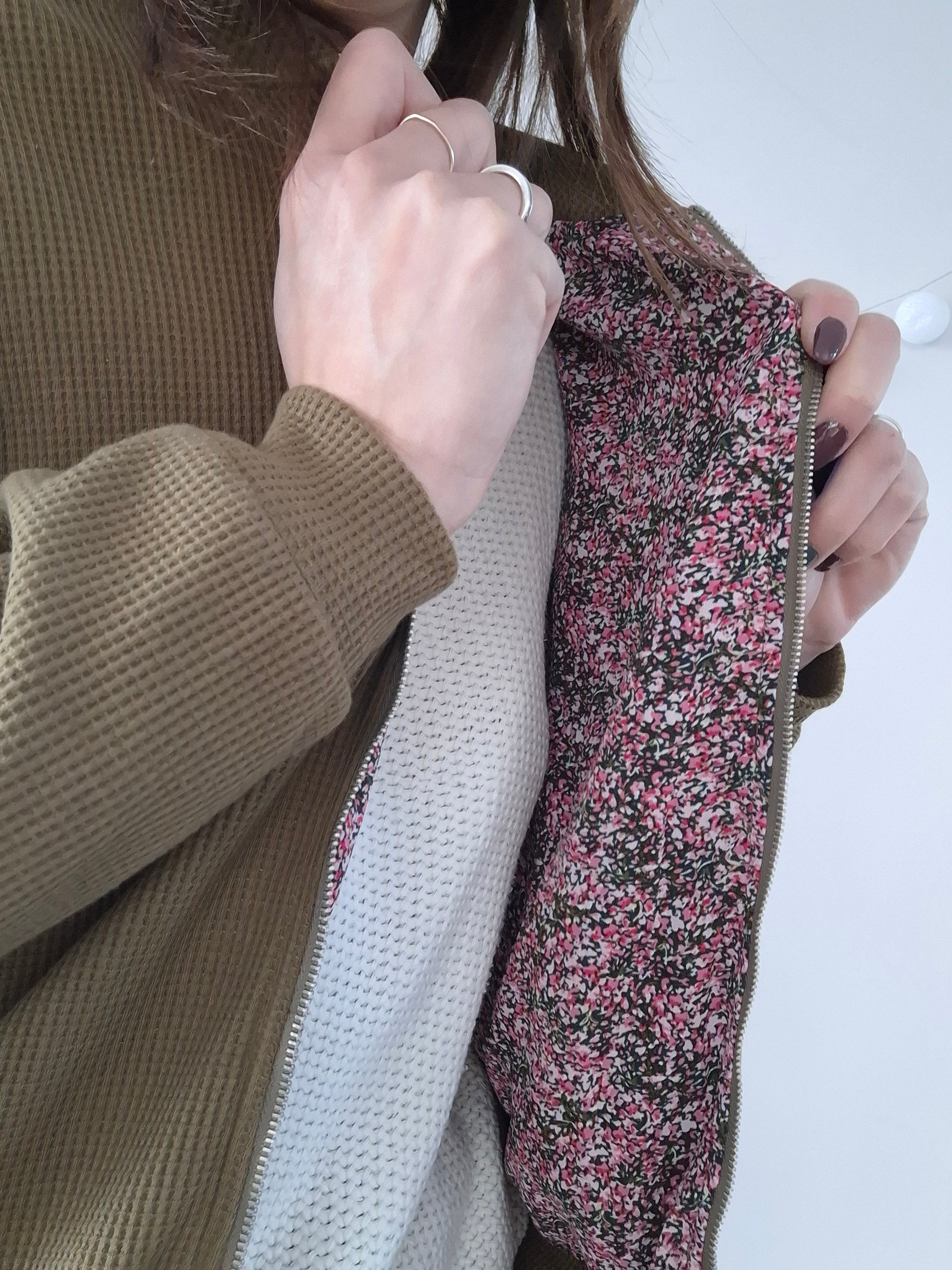 Close-up of a khaki jacket with a floral pink lining from Le Petit Placard
