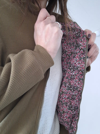 Woman showing inside of khaki Laura Jo raincoat with floral lining from Le Petit Placard