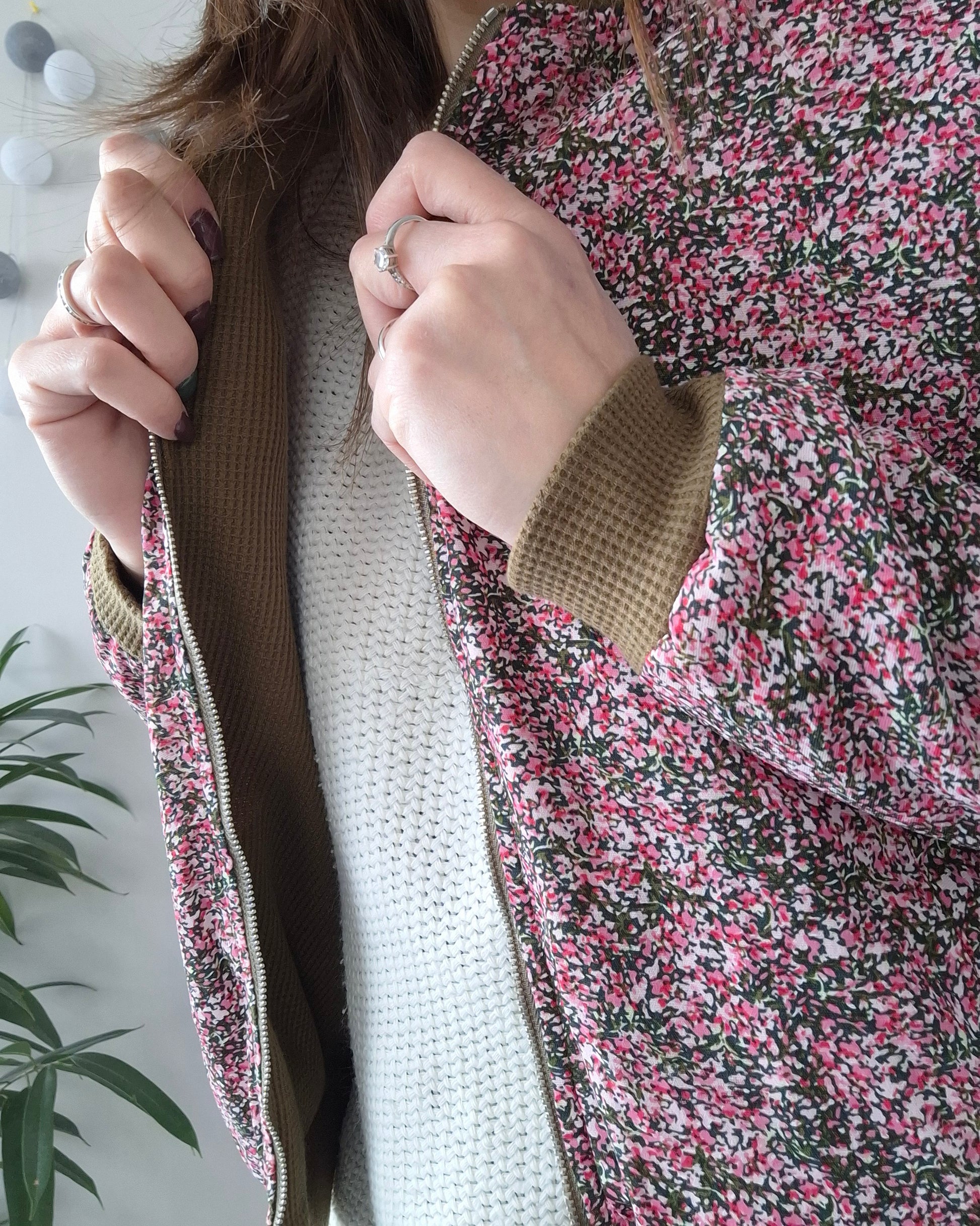 Woman wearing Laura Jo floral raincoat with pink and green pattern, Le Petit Placard