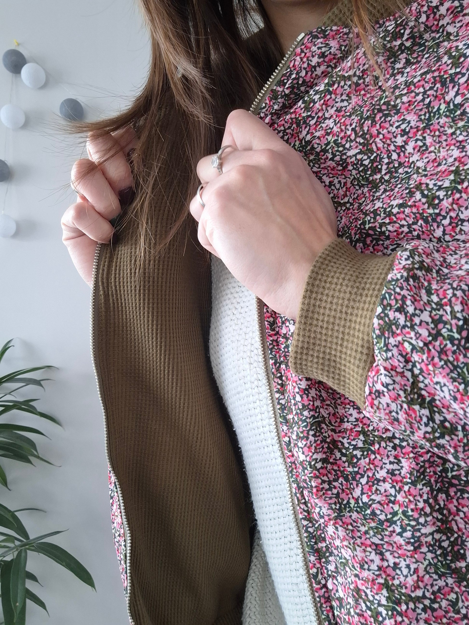 Woman wearing floral Laura Jo raincoat, opening jacket to show inner lining, Le Petit Placard