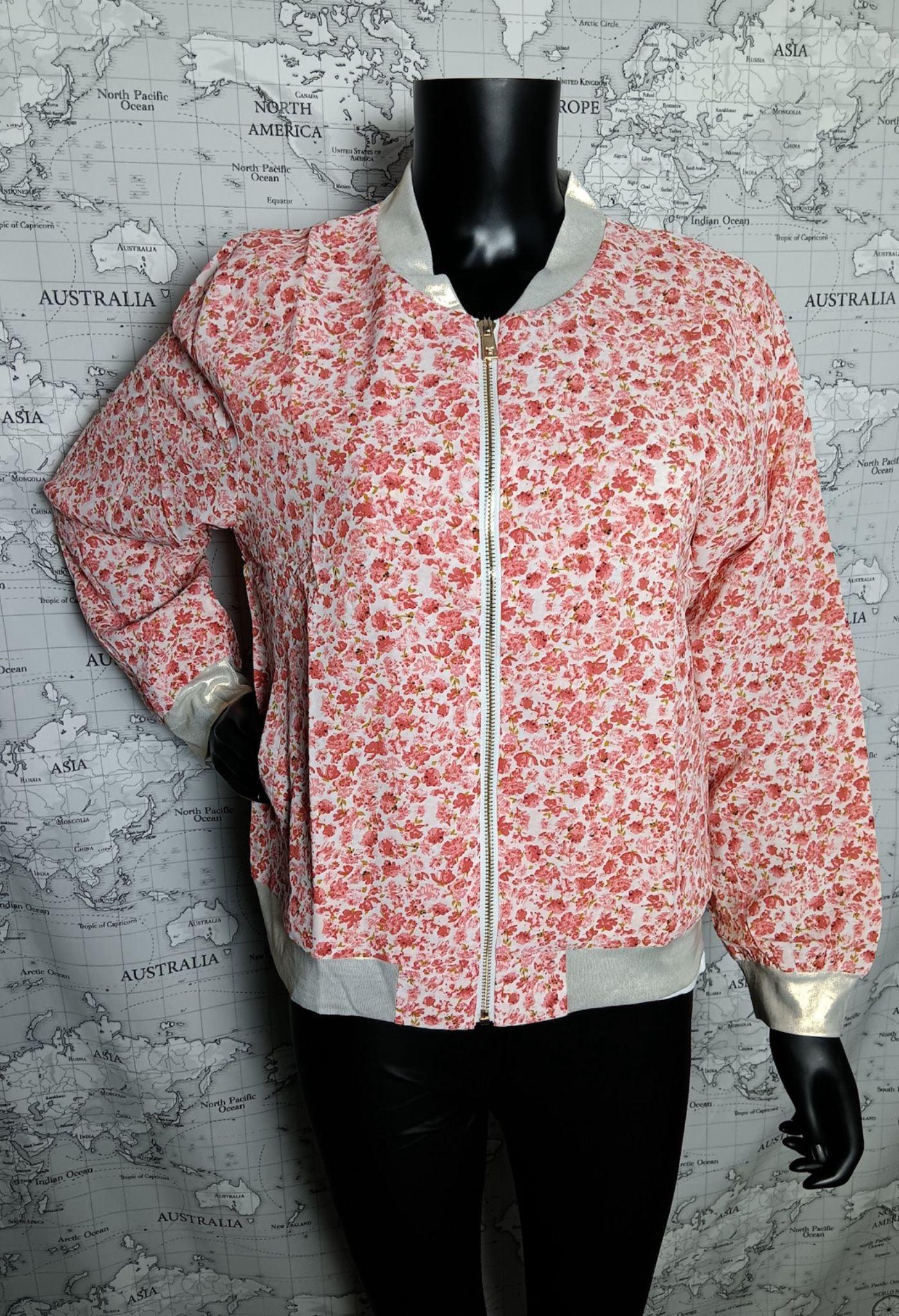 Veste bomber fleurie rose et blanc pour femme, légère avec doublure satinée gris clair et zip doré, fond carte monde.