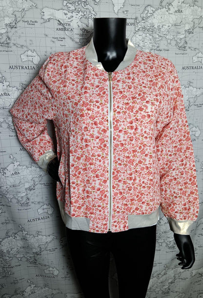 Veste bomber fleurie rose et blanc pour femme, légère avec doublure satinée gris clair et zip doré, fond carte monde.