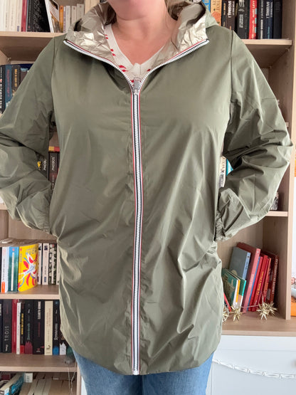 Imperméable kaki femme Melya Melody avec doublure dorée, fermeture éclair blanche et rouge, porté devant une bibliothèque
