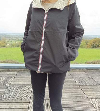 Manteau court réversible imperméable noir et doré Melya Melody porté par une femme, côté noir avec zip tricolore
