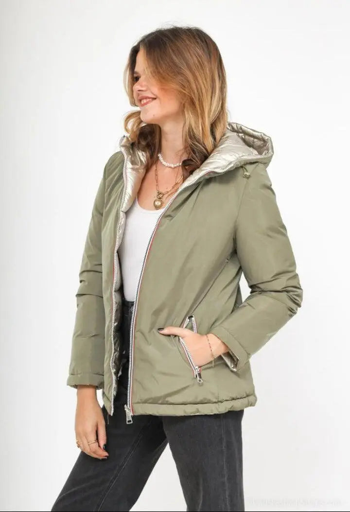Manteau réversible imperméable Melya Melody femme kaki et doré, avec capuche et poches, porté en extérieur.