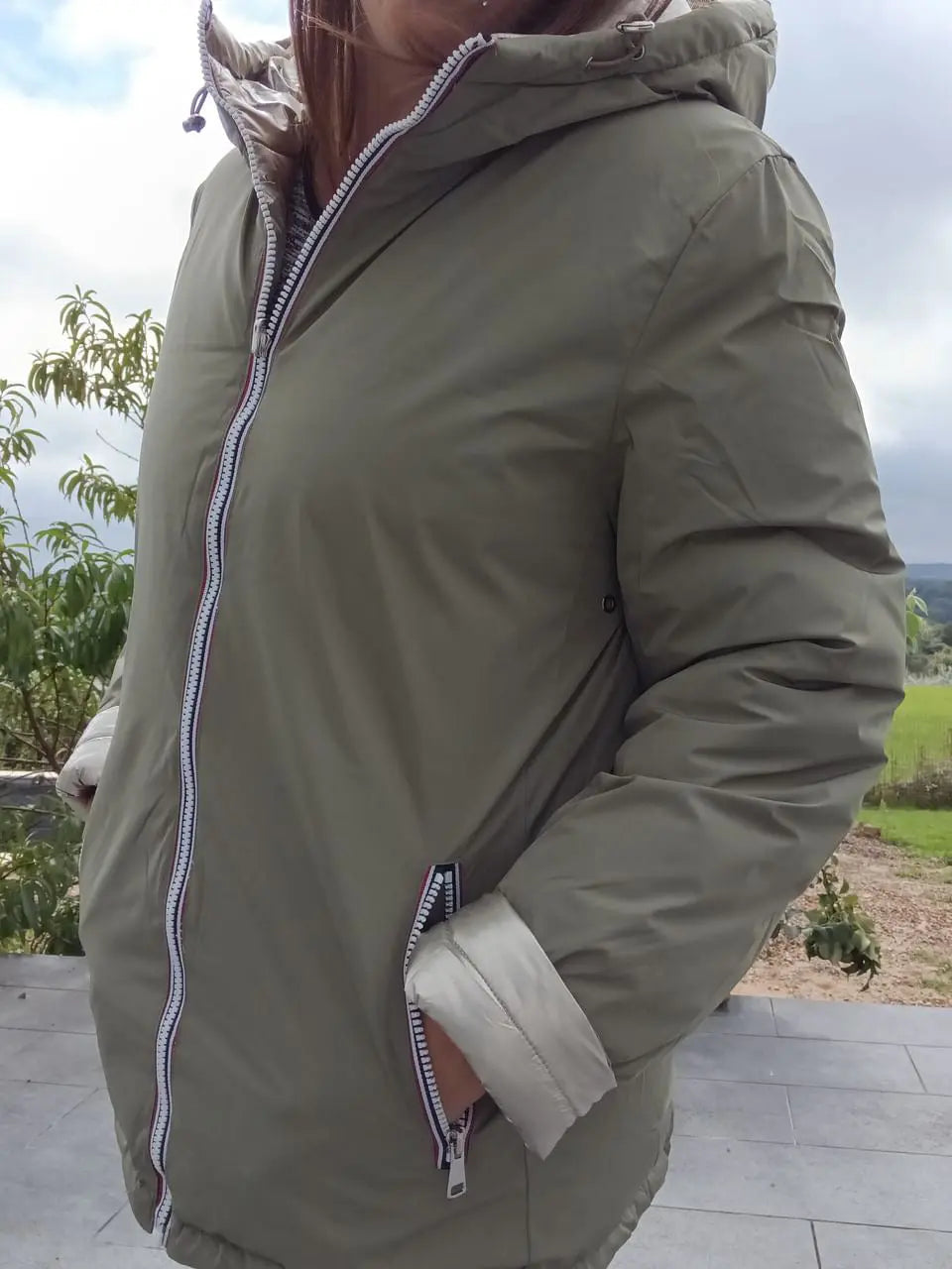 Manteau réversible imperméable Melya Melody pour femme, kaki et doré, avec capuche et poches, porté sur mannequin.