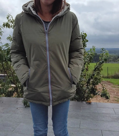 Manteau réversible imperméable Melya Melody pour femme, kaki et doré, avec capuche et poches, porté sur un fond neutre.