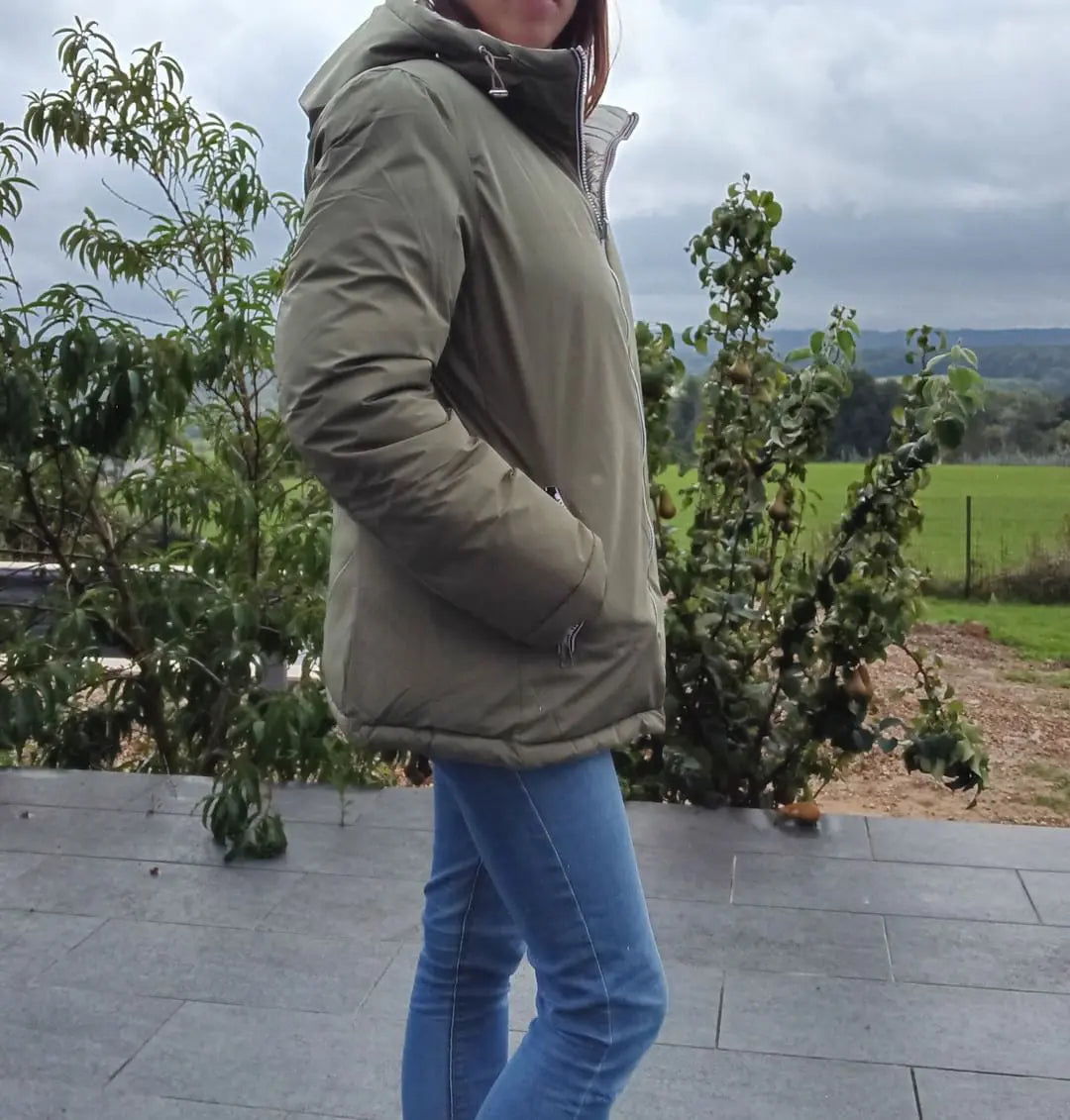 Manteau réversible imperméable Melya Melody femme kaki et doré, avec capuche et design élégant, porté en extérieur.