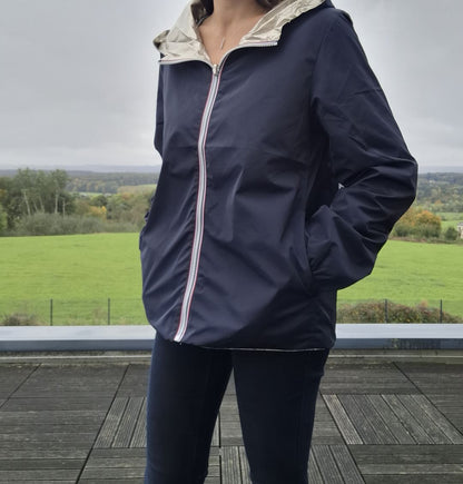 Manteau court imperméable bleu marine réversible doré Melya Melody porté par une femme, côté marine visible, capuche dorée