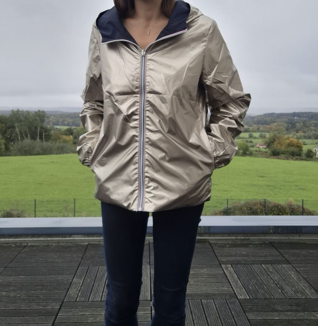 Manteau court imperméable réversible doré Melya Melody porté côté doré, avec capuche bleu marine visible