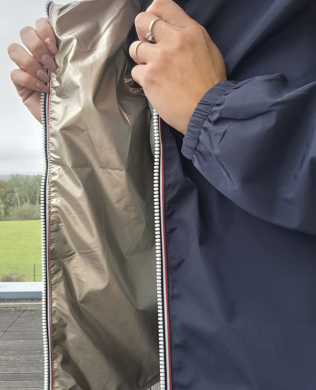 Détail intérieur doré du manteau court imperméable réversible bleu marine Melya Melody, fermeture éclair visible