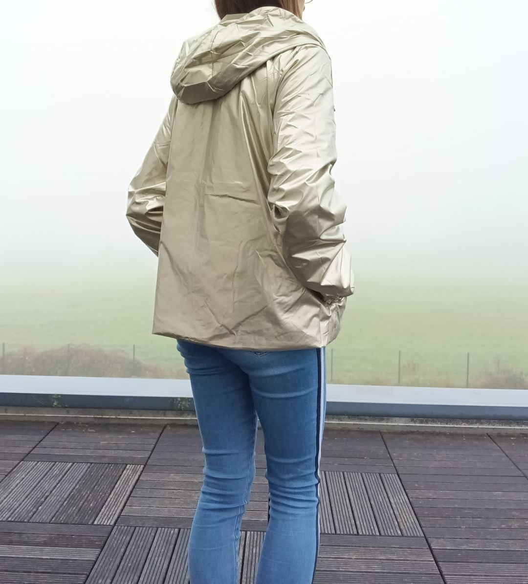 Manteau court léger imperméable réversible doré Melya Melody porté de dos avec capuche, sur jean slim bleu