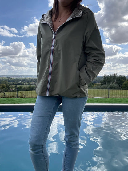 Manteau court léger imperméable kaki réversible doré Melya Melody porté avec un jean, devant une piscine