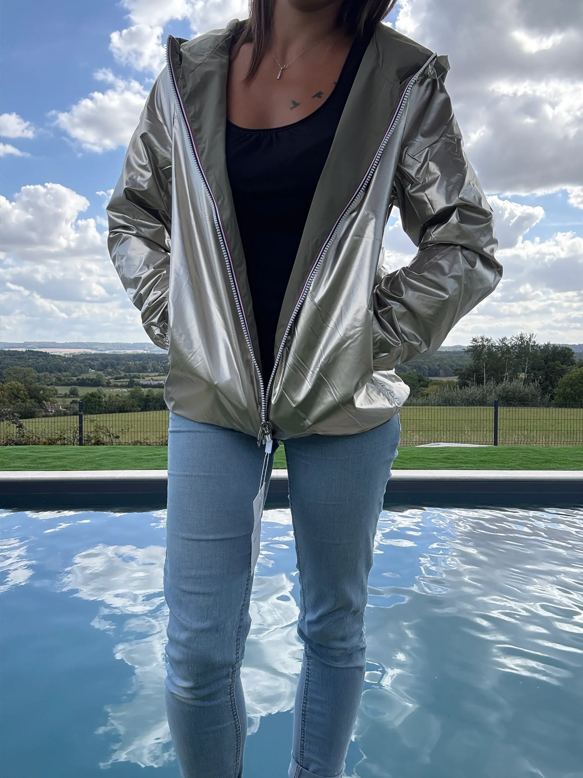 Manteau court léger imperméable kaki réversible doré Melya Melody porté ouvert sur jean, vue extérieure piscine