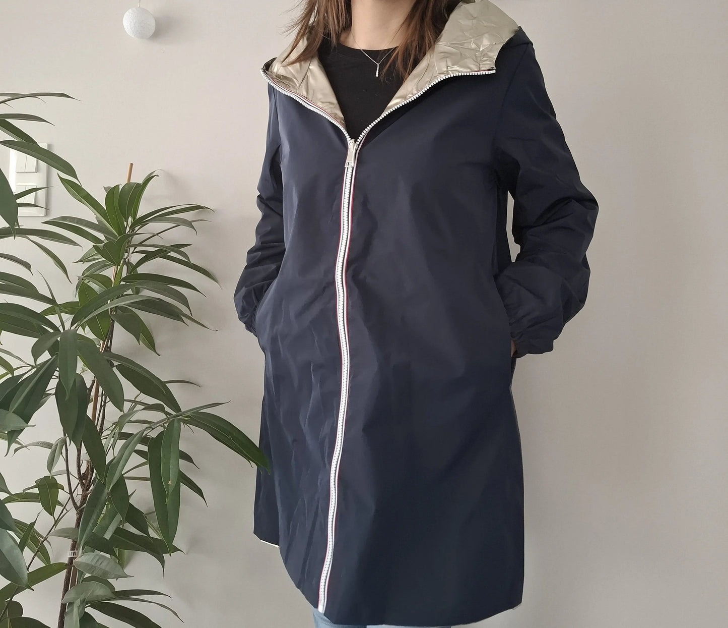 Woman wearing navy Laura Jo raincoat with hood, Le Petit Placard fashion, indoor setting