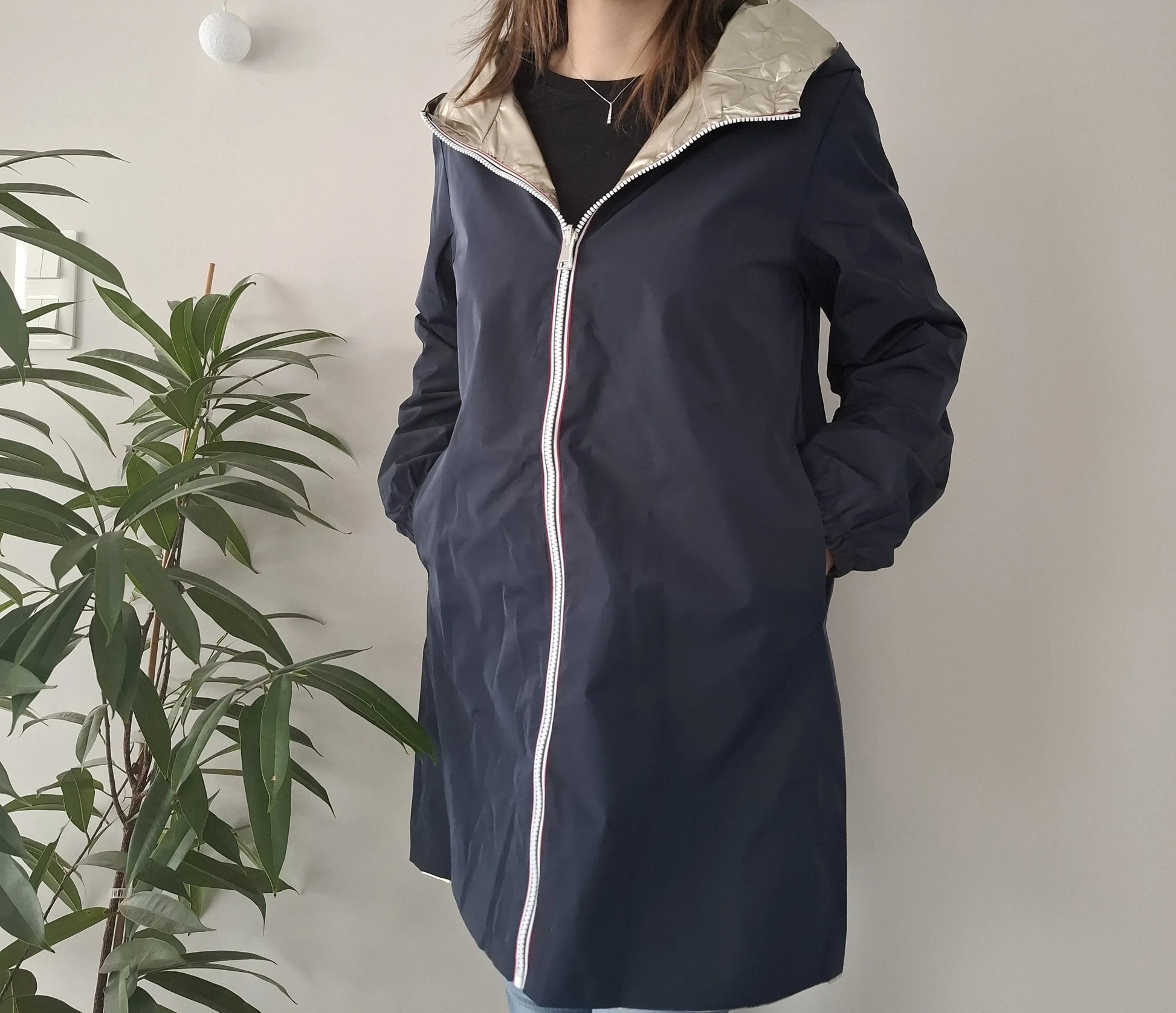 Woman wearing navy Laura Jo raincoat with hood, Le Petit Placard fashion, indoor setting