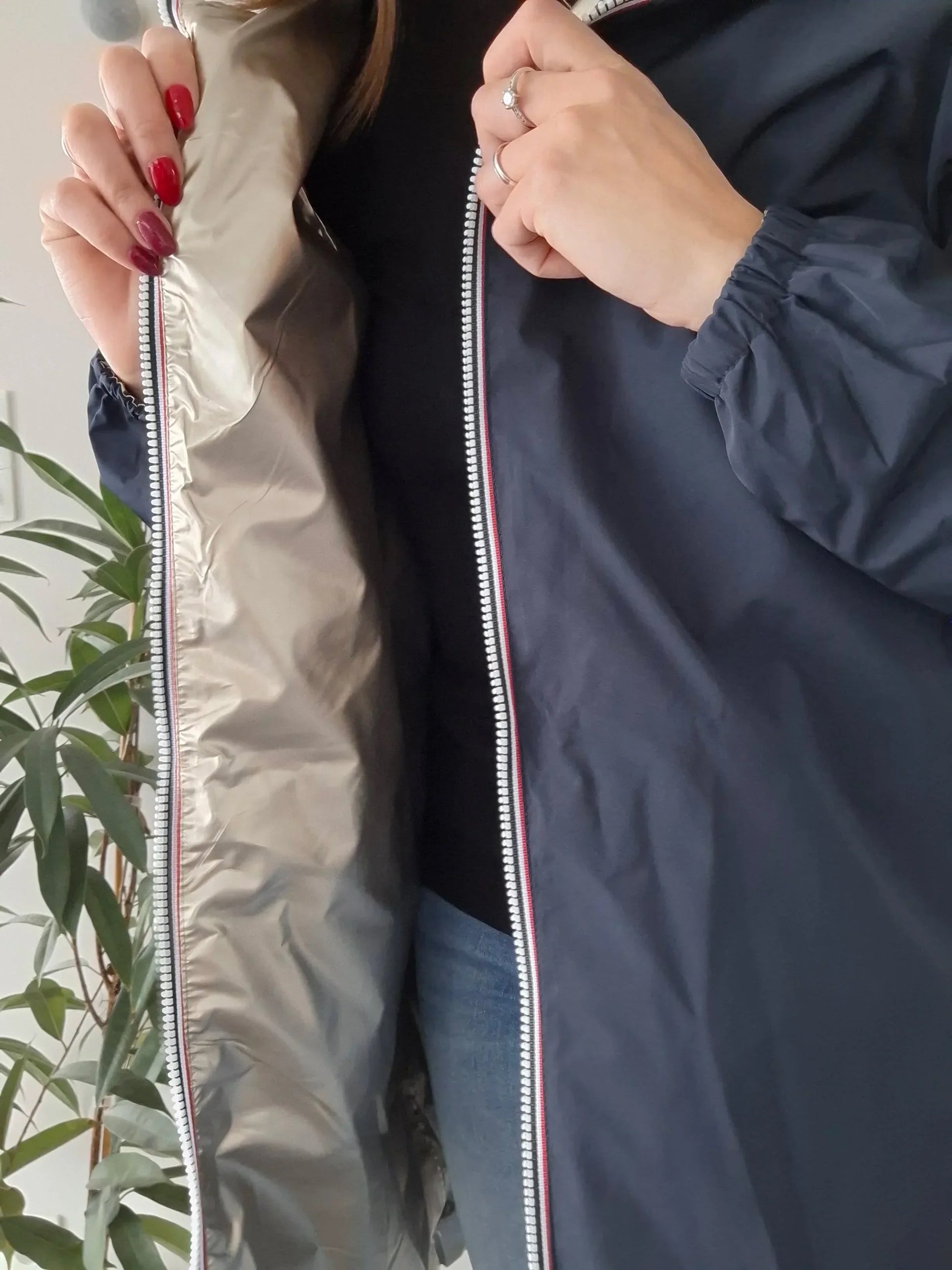 Woman showcasing navy Laura Jo raincoat with metallic lining from Le Petit Placard