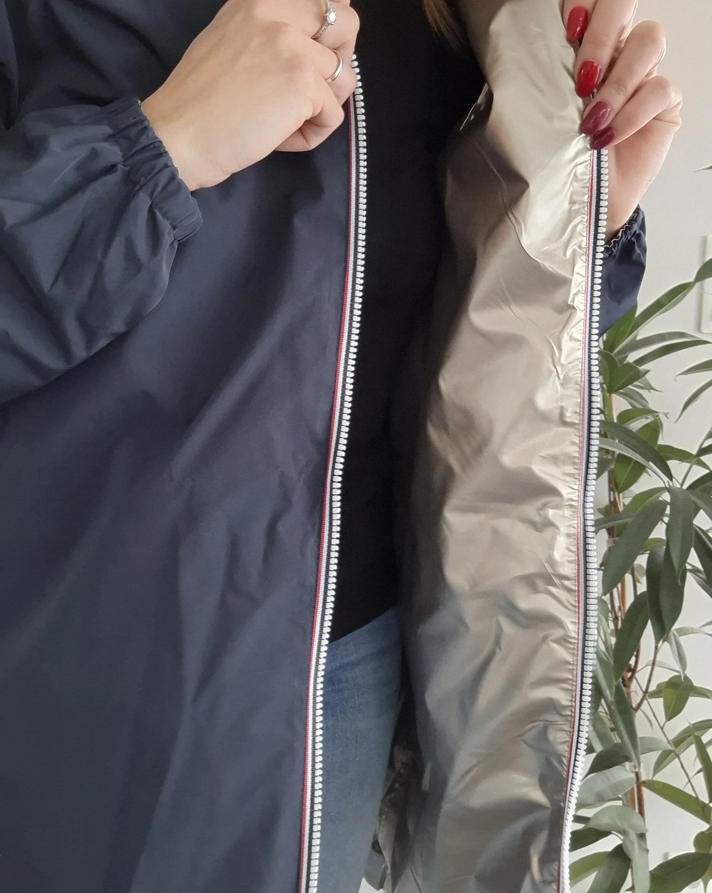 Woman showing inside of Laura Jo navy raincoat from Le Petit Placard, casual look