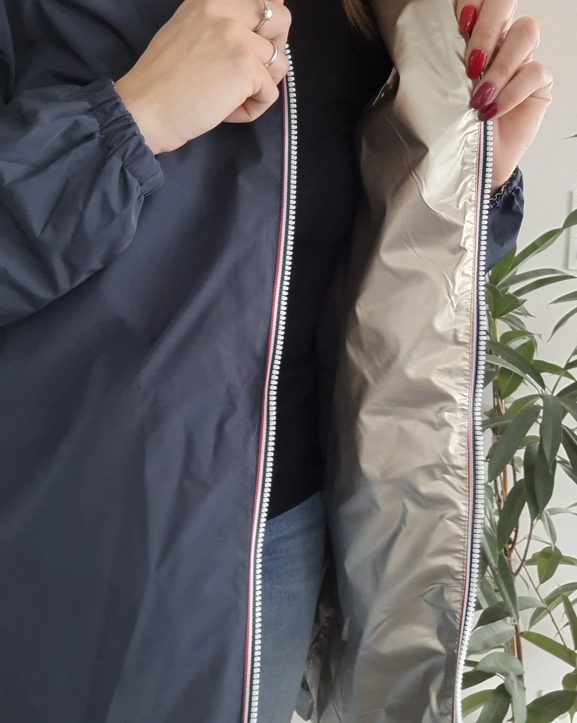 Woman showing inside of Laura Jo navy raincoat from Le Petit Placard, casual look