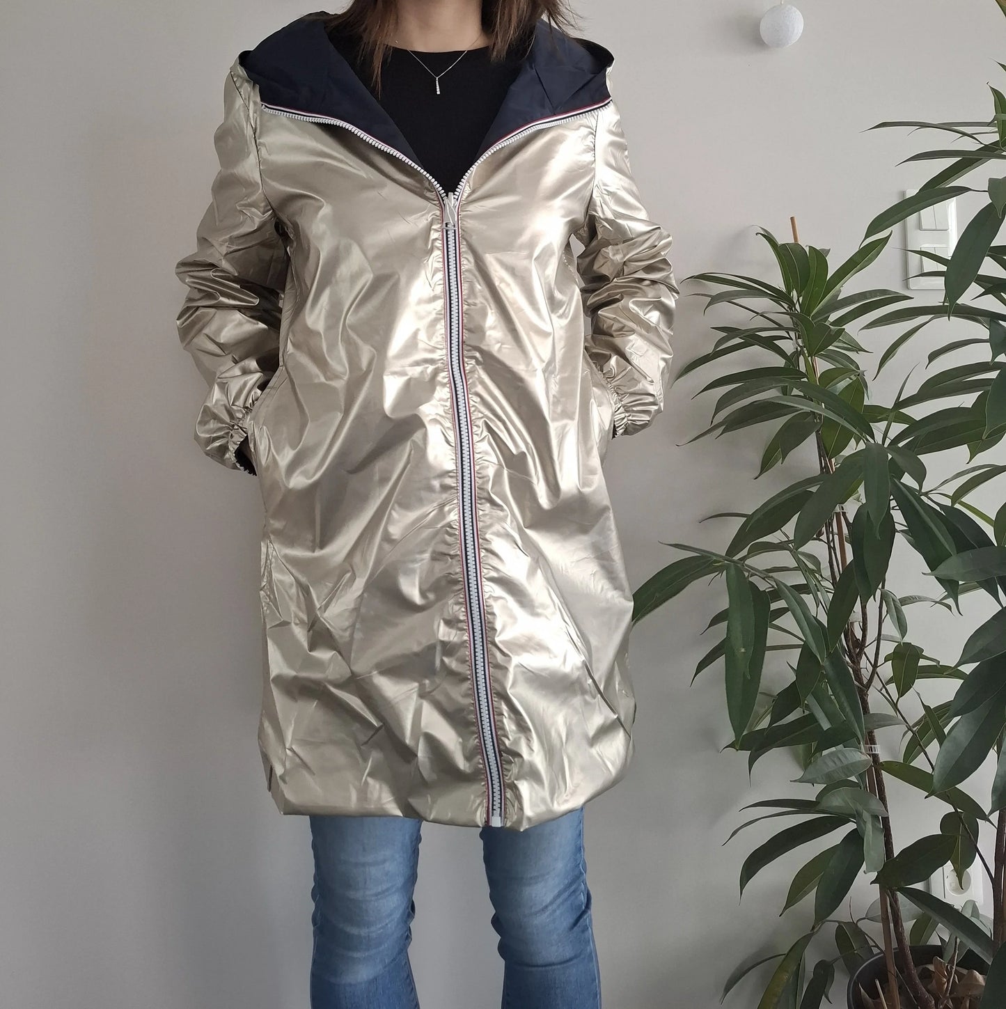 Woman wearing a shiny gold Laura Jo raincoat, casual jeans, indoor setting, Le Petit Placard