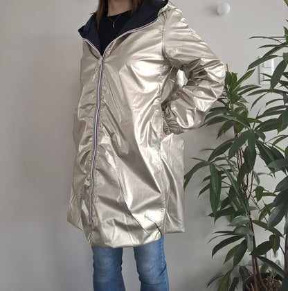 Woman wearing a shiny gold Laura Jo raincoat from Le Petit Placard, standing indoors